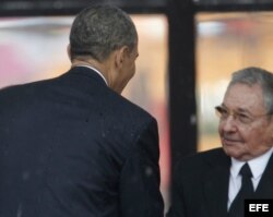 El presidente estadounidense, Barack Obama (i), saludó a Raúl Castro, durante el servicio religioso oficial del expresidente sudafricano Nelson Mandela.