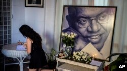 Una mujer escribe en un libro en un altar del fallecido cantautor cubano Pablo Milanés. (AP/Ramon Espinosa).