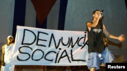 En una presentación el rapero Papá Humbertico critica los arrestos policiales y la discriminación racial en Cuba mientras exhibe el estandarte "Denuncia Social" en el Festival de Rap 2002. REUTERS/Rafael Pérez.
