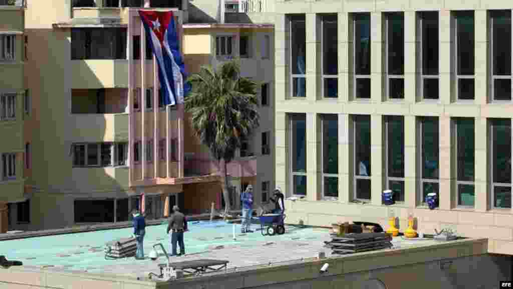 Trabajadores cubanos y estadounidenses ultiman detalles dentro y fuera de la Embajada de Estados Unidos en La Habana. 