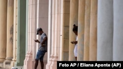 La gente usa sus teléfonos celulares donde una conexión wifi pública prepaga funciona cerca del malecón en La Habana, Cuba, el martes 14 de julio de 2021.