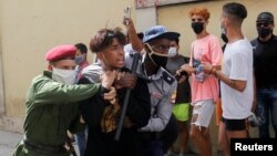 Policías vestidos de civil detienen a una persona durante protestas el 11 de julio de 2021. REUTERS / Stringer