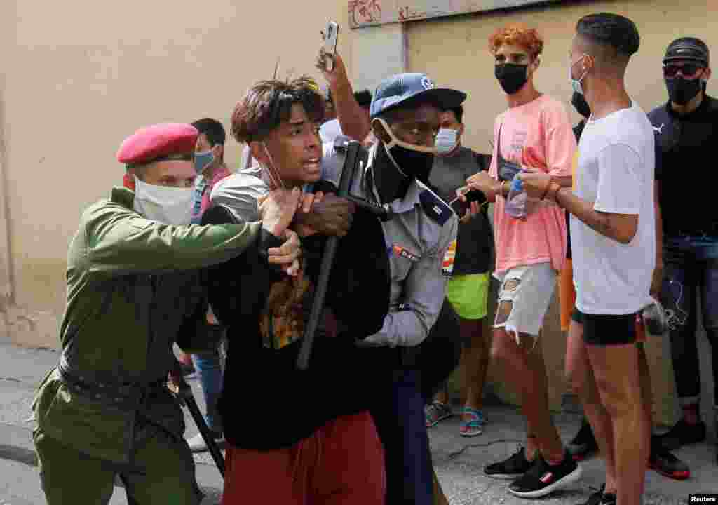 Polic&#237;as vestidos de civil detienen a una persona durante protestas el 11 de julio de 2021. REUTERS / Stringer
