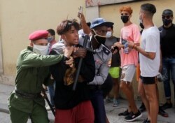 Policías vestidos de civil detienen a una persona durante protestas el 11 de julio de 2021. REUTERS / Stringer