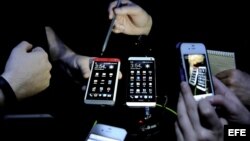 Varias personas prueban el nuevo modelo de teléfono inteligente de la marca HTC, el HTC One, en un evento de Nueva York, EE.UU. 