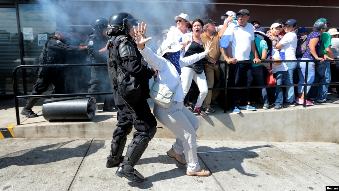 Manifestantes de la marcha "Unidos por la libertad" en Managua, Nicaragua, son reprimidos por policías antidisturbios el 14 de octubre de 2018.