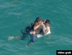 Asidos a un pedazo de su balsa naufragada dos cubanos esperan ser rescatados cerca de Turkey Point, al sur de Miami (WSVN 7).