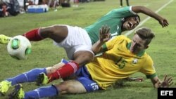 El jugador brasileño Leo Pereira (d) lucha por el balón con el mexicano Marco Granados durante el partido Brasil-México, de cuartos de final del Mundial sub-17 de fútbol, en el estadio Al-Ahli's de Dubai, Emiratos Árabes Unidos.