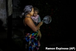 Una madre con su hijo en brazos protesta golpeando una cazuela en La Habana, el 20 de octubre de 2024. (AP/Ramon Espinosa)