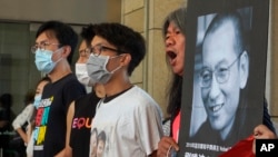 Activistas en Hong Kong, frente a una imagen de Liu Xiaobo, el 13 de julio de 2020. (AP/Vincent Yu)