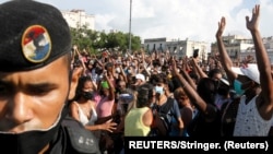 La gente reacciona durante las protestas contra y en apoyo del gobierno, en medio del brote de la enfermedad del coronavirus (COVID-19), en La Habana, Cuba, el 11 de julio de 2021. REUTERS/Stringer.