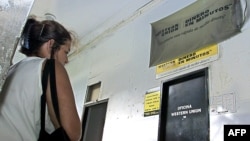 Una cubana espera afuera de una oficina de Western Union para cobrar dinero de familiares en EE.UU.