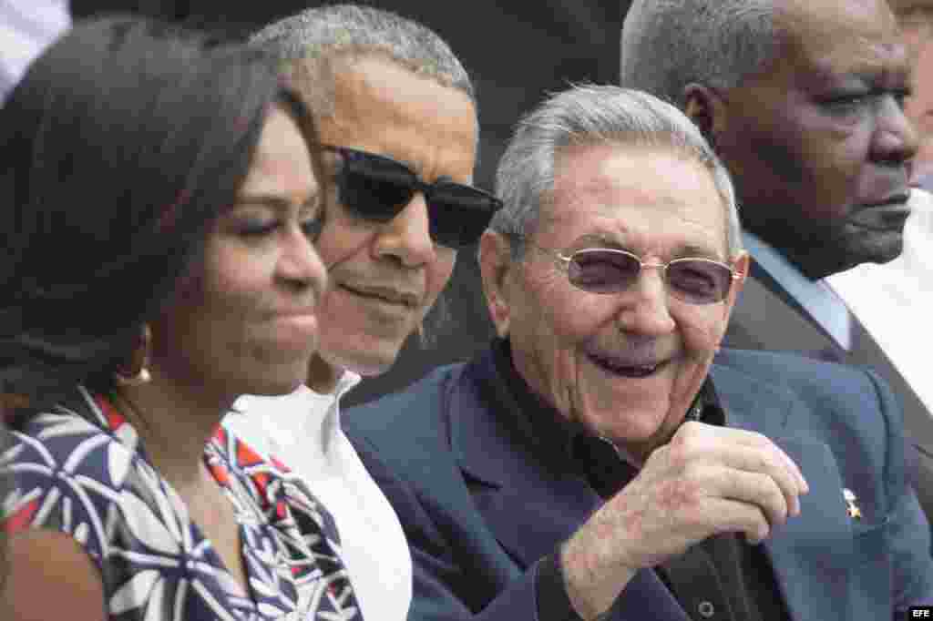 Barack y Michelle Obama conversan con el gobernante cubano, Raúl Castro, durante el juego de béisbol en el Latino.