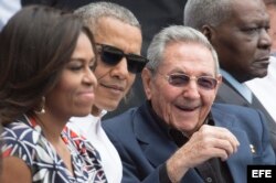 Barack y Michelle Obama conversan con el presidente cubano, Raúl Castro, durante el partido de béisbol en el Latino.