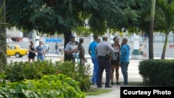 Policías solicitan identificación a jóvenes en el Parque Central, La Habana. Foto: Ernesto Pérez Chang (cortesía).
