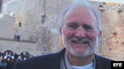 Una persona sostiene una pancarta en la que pide que sea liberado el contratista Alan Gross. 