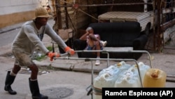 Un hombre empuja un carrito lleno de bidones de agua en La Habana, el 27 de agosto de 2026. (AP/Ramón Espinosa)