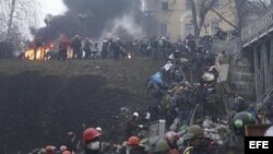 Activistas de la oposición suben por una colina en los alrededores de la Plaza de la Independencia durante los enfrentamientos con la policía en Kiev (Ucrania) hoy, jueves 20 de febrero de 2104.