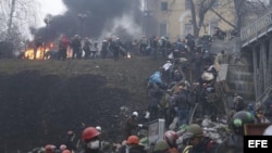 Activistas de la oposición suben por una colina en los alrededores de la Plaza de la Independencia durante los enfrentamientos con la policía en Kiev (Ucrania) hoy, jueves 20 de febrero de 2104.