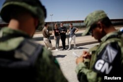 Un agente del Instituto Nacional de Inmigración habla con cubanos detenidos mientras intentaban cruzar ilegalmente la frontera entre los Estados Unidos y México, en Ciudad Juárez.