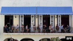 Varios turistas permanecen en el balcón de un restaurante privado en La Habana.