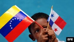 Un niño panameño sostiene la bandera de su país y la de Venezuela. 
