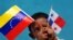 Un niño panameño sostiene la bandera de su país y la de Venezuela. 