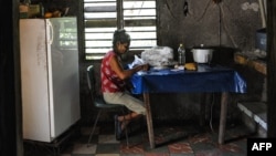 Una cubana escoge arroz, en su casa, en la localidad de El Caney, en Santiago de Cuba. (Yamil/Lage/AFP/Archivo)