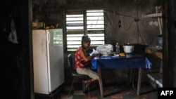 FOTO ARCHIVO. Una señora escoge arroz en su casa en El Caney, Santiago de Cuba. El arroz es un componente fundamental en la dieta de los cubanos.