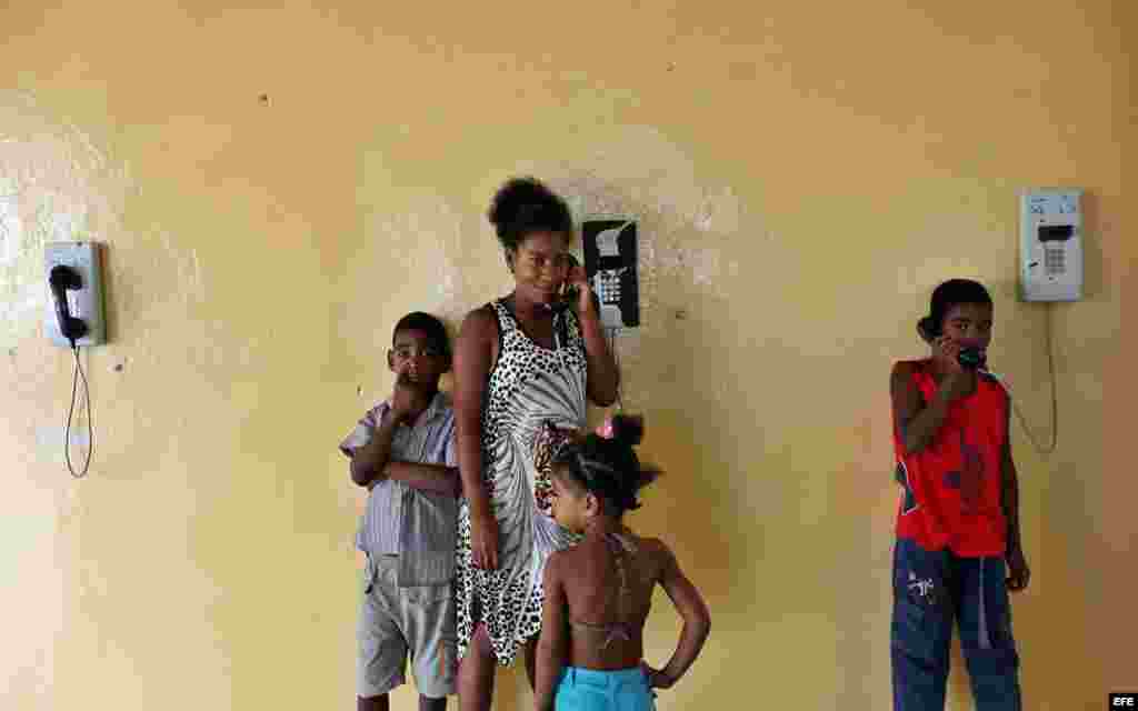Una joven y sus hijos hablan por teléfono en un albergue organizado en una escuela hoy, lunes 03 de octubre de 2016, en la ciudad de Guantánamo (Cuba), ante la proximidad del huracán Matthew. Seis provincias de Cuba se encuentran bajo "alarma ciclónica" a
