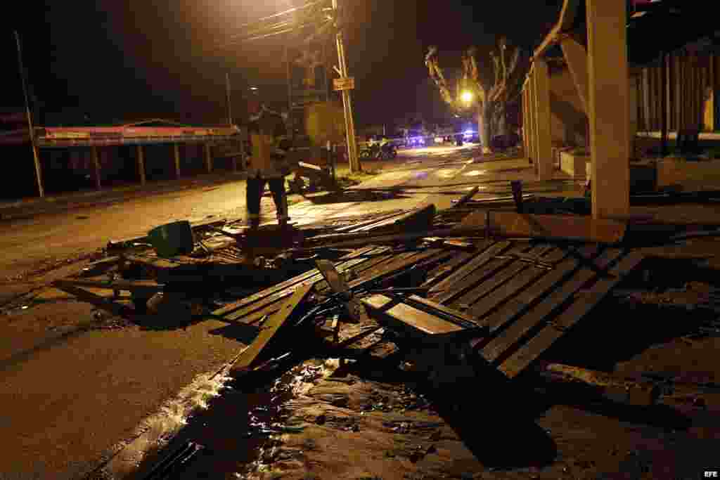 Un bombero pasa al lado de destrozos causados en Con Con, cerca de Valparaíso, por la penetración del mar que siguió al sismo, 