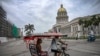 Un bicitaxi decorado con una bandera estadounidense pasa frente al Capitolio de La Habana el 11 de julio de 2026.