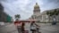 Un bicitaxi decorado con una bandera estadounidense pasa frente al Capitolio de La Habana el 11 de julio de 2026.