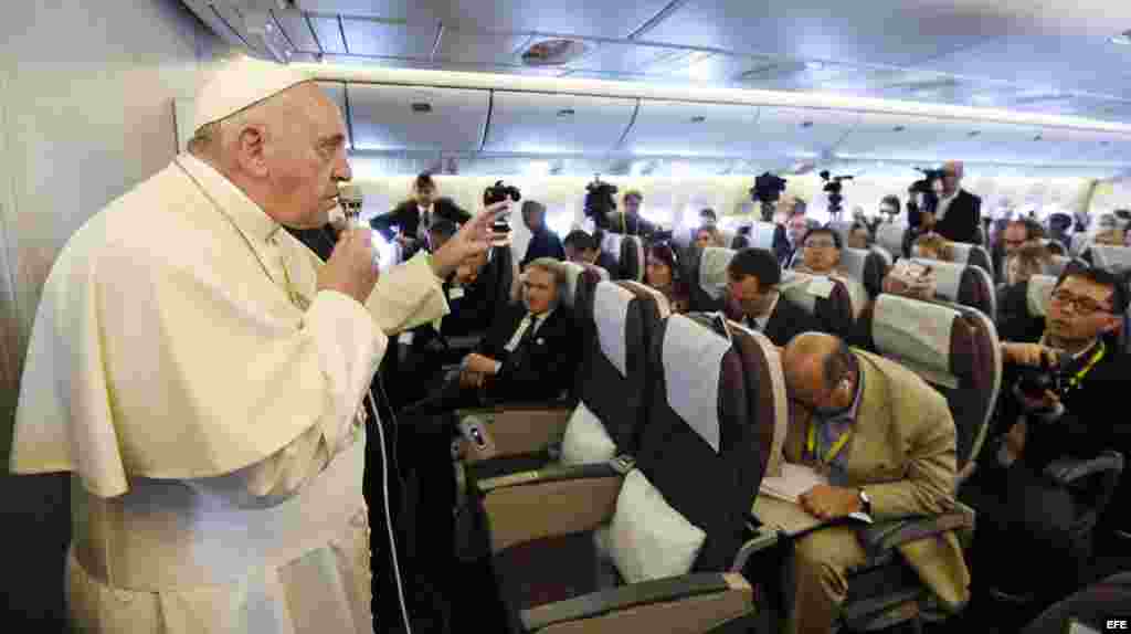 El papa Francisco (i) se dirige a los periodistas durante el vuelo del Boeing 777 de la compañía Korean Airlines.