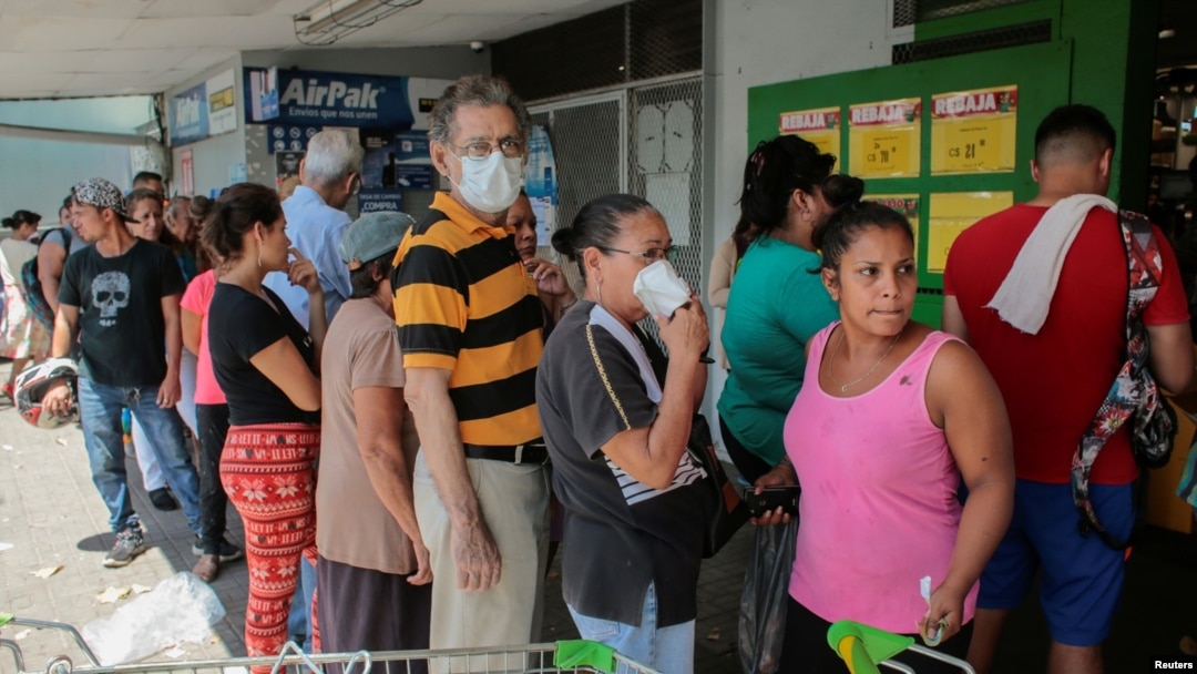 La gente espera en fila para comprar comida en un supermercado de La Habana. 