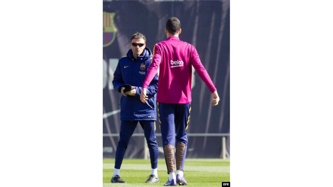 Luis Enrique (i) habla con el centrocampista Sergio Busquets (d) durante la sesión de entrenamiento.