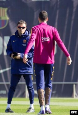 Luis Enrique (i) habla con el centrocampista Sergio Busquets (d) durante la sesión de entrenamiento.