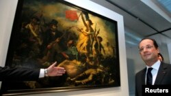ARCHIVO. El presidente francés Francois Hollande posa delante de la obra "La Liberte Guidant le Peuple, 1830" de Eugene Delacroix.