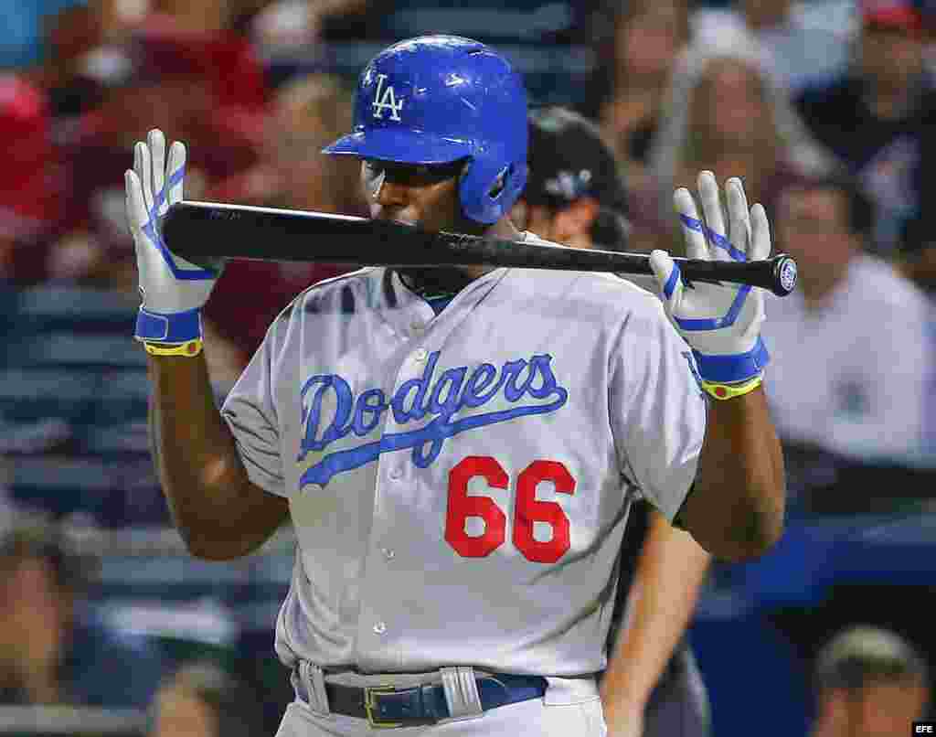 Yasiel Puig de los Dodgers de los Ángeles muerde su bate en el partido ante los Bravos de Atlanta.