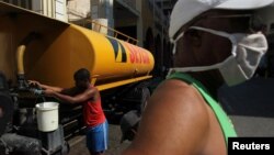 Cubanos almacenan agua en La Habana en medio de la crisis por el coronavirus. Las autoridades están amenazando y multando a miembros de la sociedad civil que reporten sobre la situación de la pandemia en la isla.