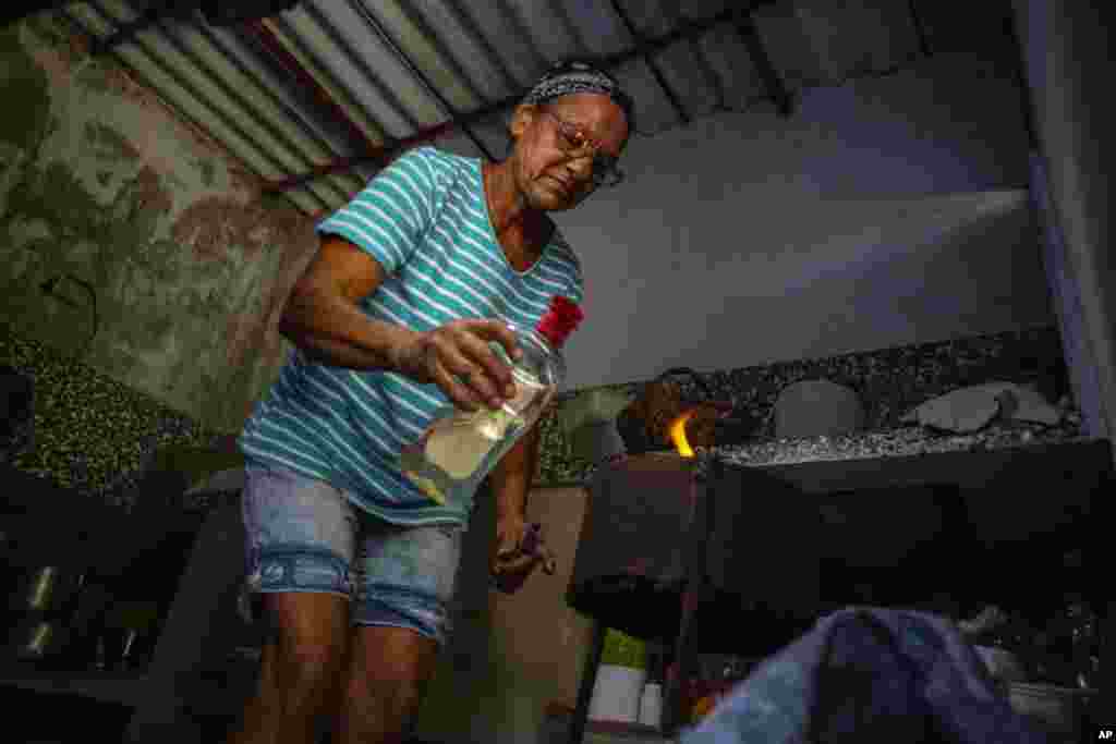 Una cubana enciende su cocina de carbón en el Mariel.&nbsp;