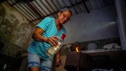 Rosa López enciende una estufa de carbón en Mariel, Cuba, el 18 de mayo de 2023. (Foto AP/Ramon Espinosa)