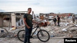 Enrique Marín, de 48 años, quien perdió a su madre en el terremoto, junto a edificios destruidos en Pereira, Colombia.
