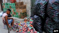 Un hombre selecciona latas vacías en un mercado de La Habana. AFP PHOTO / YAMIL LAGE