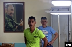 Dos hombres junto a un retrato del fallecido líder cubano Fidel Castro en La Habana (Cuba).