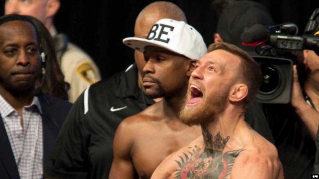 El campeón de la UFC, Conor McGregor (d) reacciona junto al boxeador estadounidense Floyd Mayweather (c).