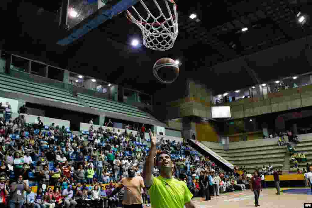 El candidato presidencial de la oposici&oacute;n a la presidencia de Venezuela, Henrique Capriles (d), lanza un bal&oacute;n hoy, viernes 12 de abril de 2013, durante un partido de baloncesto junto a periodistas deportivos e integrantes del equipo Panteras de Miranda 