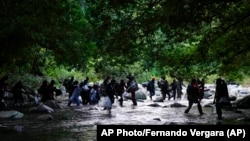 Migrantes en el río Acandí, en Colombia, en su ruta hasta Panamá por la Selva del Darién. AP Photo/Fernando Vergara)