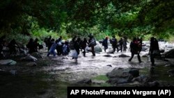 Migrantes en el río Acandí, en Colombia, en su ruta hasta Panamá por la Selva del Darién. AP Photo/Fernando Vergara)