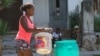 Una mujer traslada un tanque en una carretilla para abastecerse de agua ante la crisis de suministro en la capital cubana